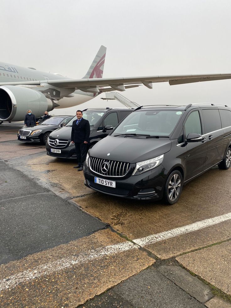 Three polished black luxury Mercedes-Benz vans and sedans from the SRB Limo fleet lined up on an airport tarmac next to a large private aircraft, with a professional chauffeur standing by