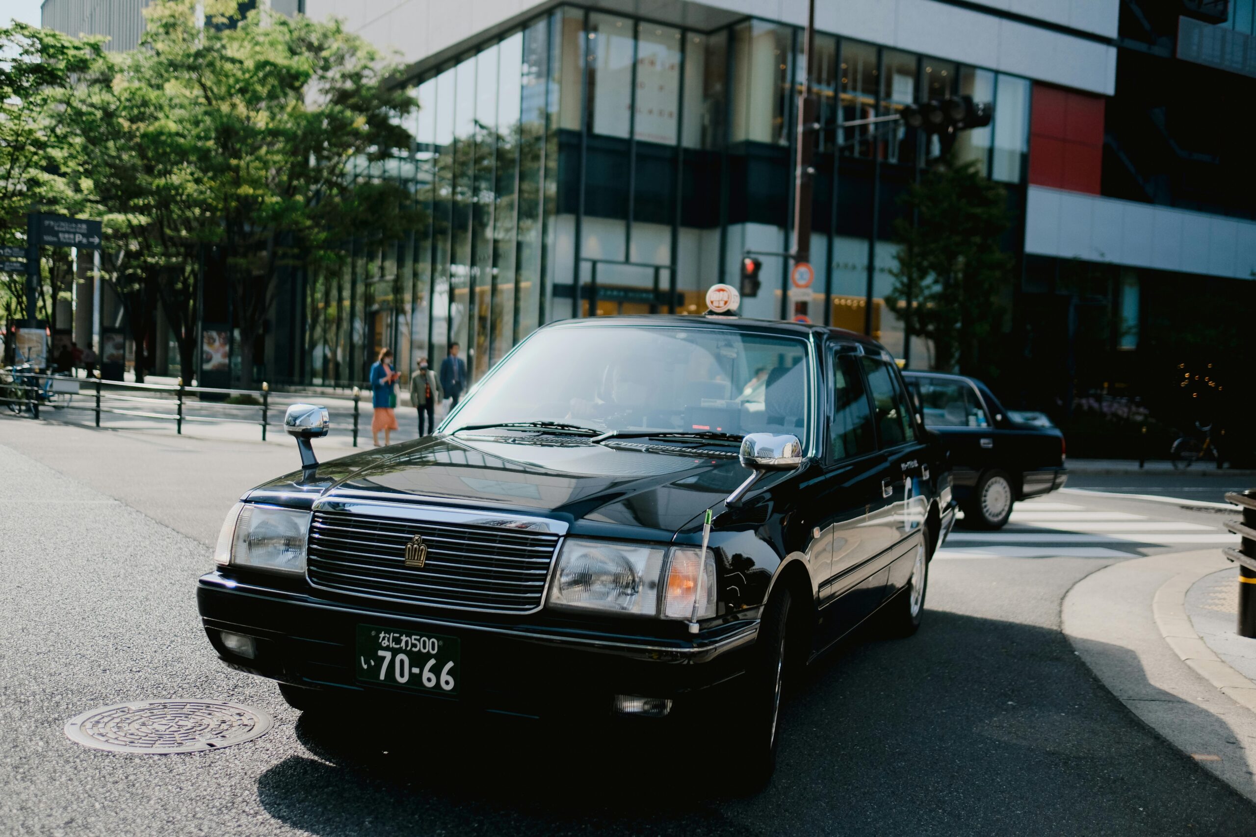 A classic black luxury sedan driving in the city, representing our professional Queen Creek limo service.